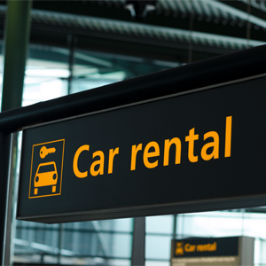 A black and yellow sign that says Car Rental